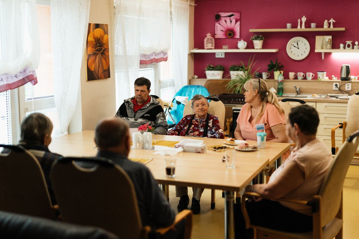 Personnes âgées et proches partageant un repas convivial lors d'un séjour aidant-aidé en Bretagne