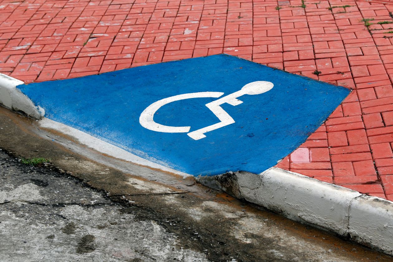 Rampe d'accès et pictogramme d'accessibilité en fauteuil roulant, symbole du label Tourisme et Handicap