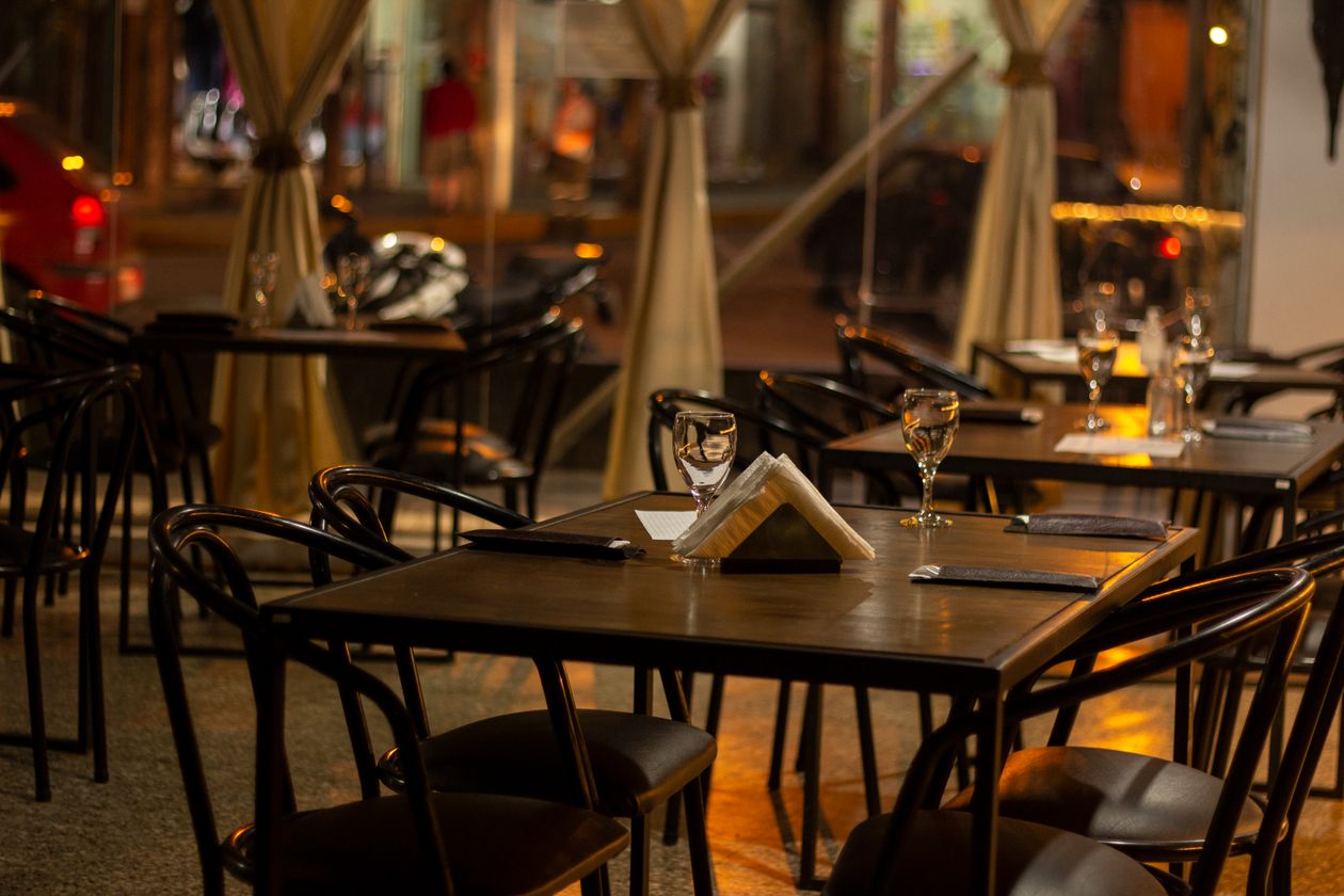 Salle de restaurant dressée et chaleureusement éclairée pour le service du soir, où se prend le dîner d'une soirée étape