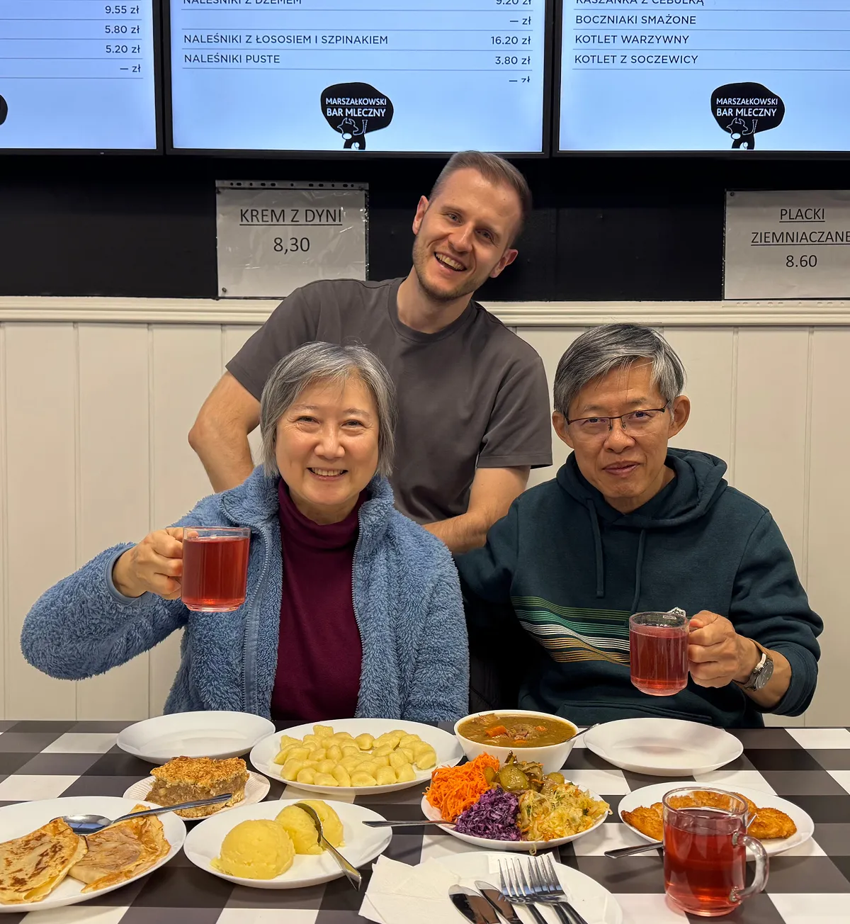 Guide with two guests sharing traditional Polish dishes at a milk bar