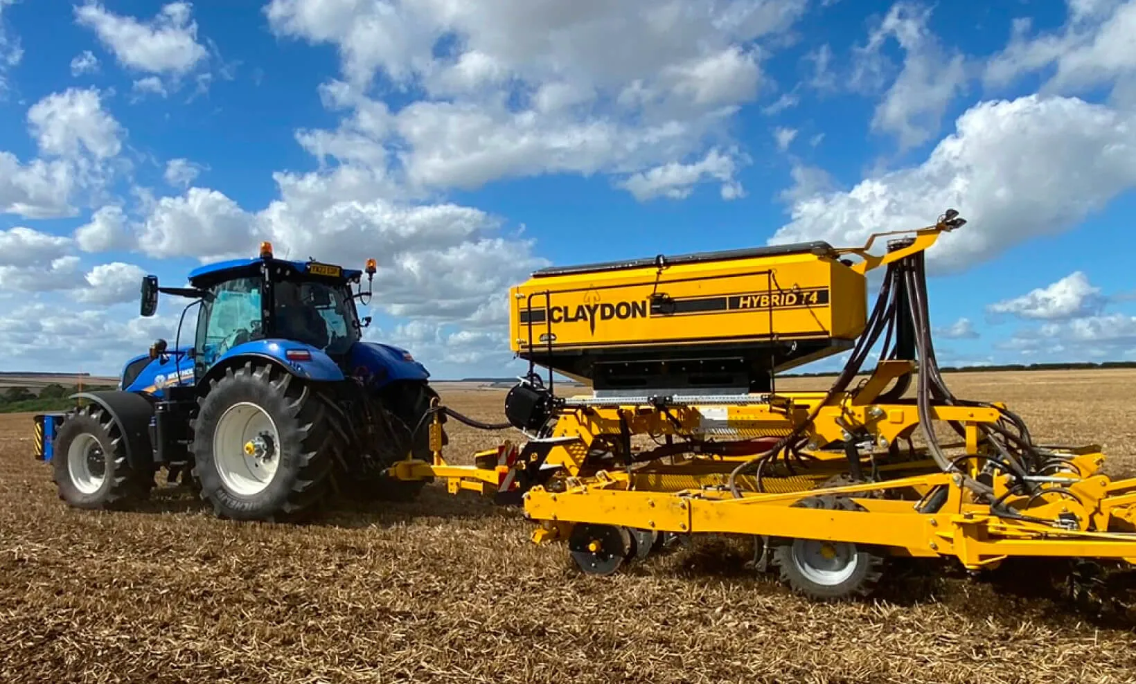 Traktor mit angebauter Sämaschine bei der Bodenbearbeitung auf einem landwirtschaftlichen Feld