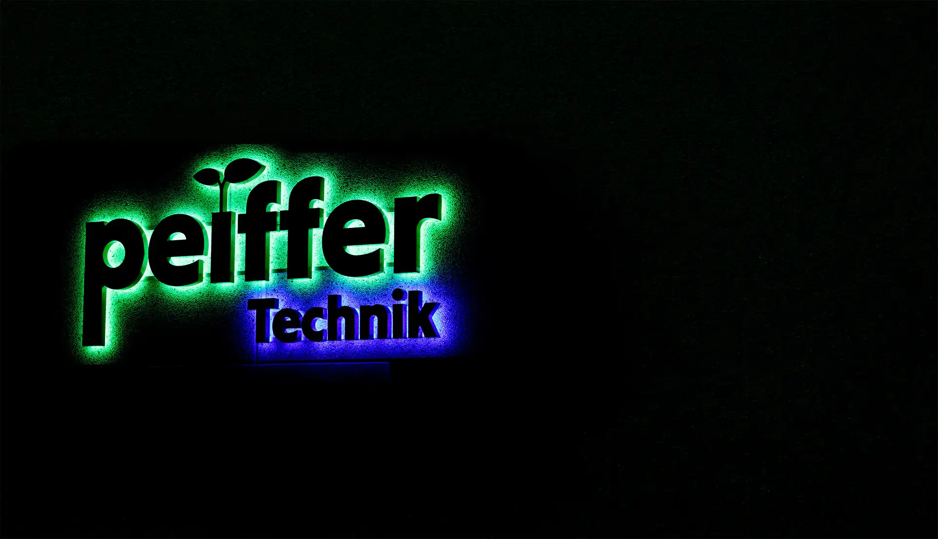 Beleuchtetes Peiffer-Technik-Firmenschild bei Nacht