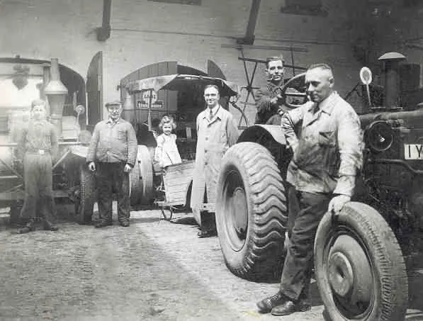 Familie und Mitarbeiter neben dem ersten von Peiffer verkauften Traktor, 1936