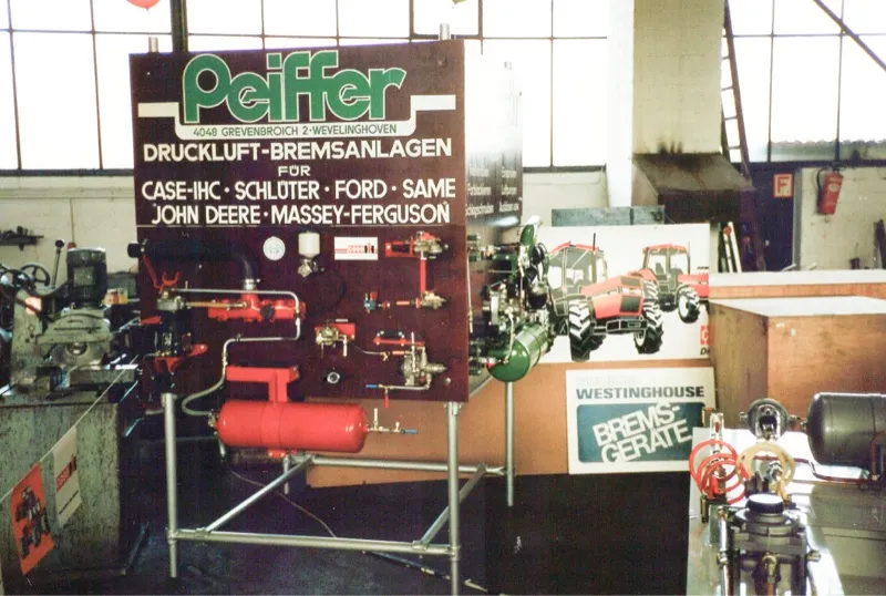 Messestand für Peiffer Druckluft-Bremsanlagen mit roten Druckluftbehältern, 1982