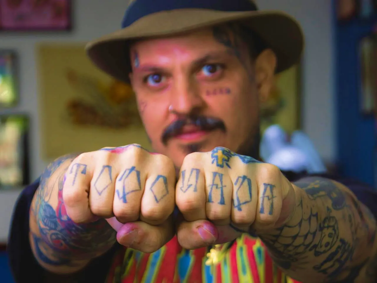 young tattooed man showing his fists