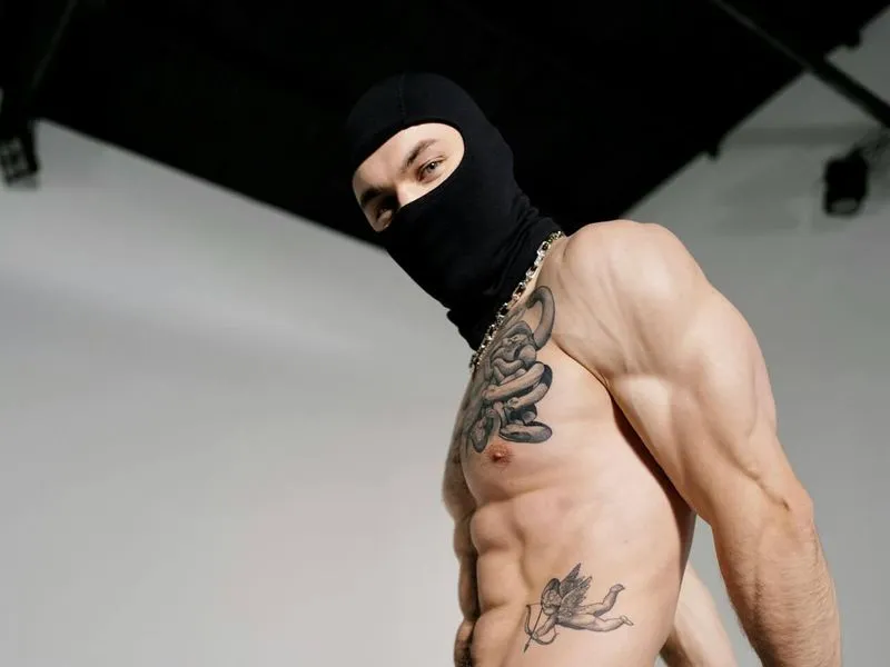 shirtless man in balaclava posing in studio