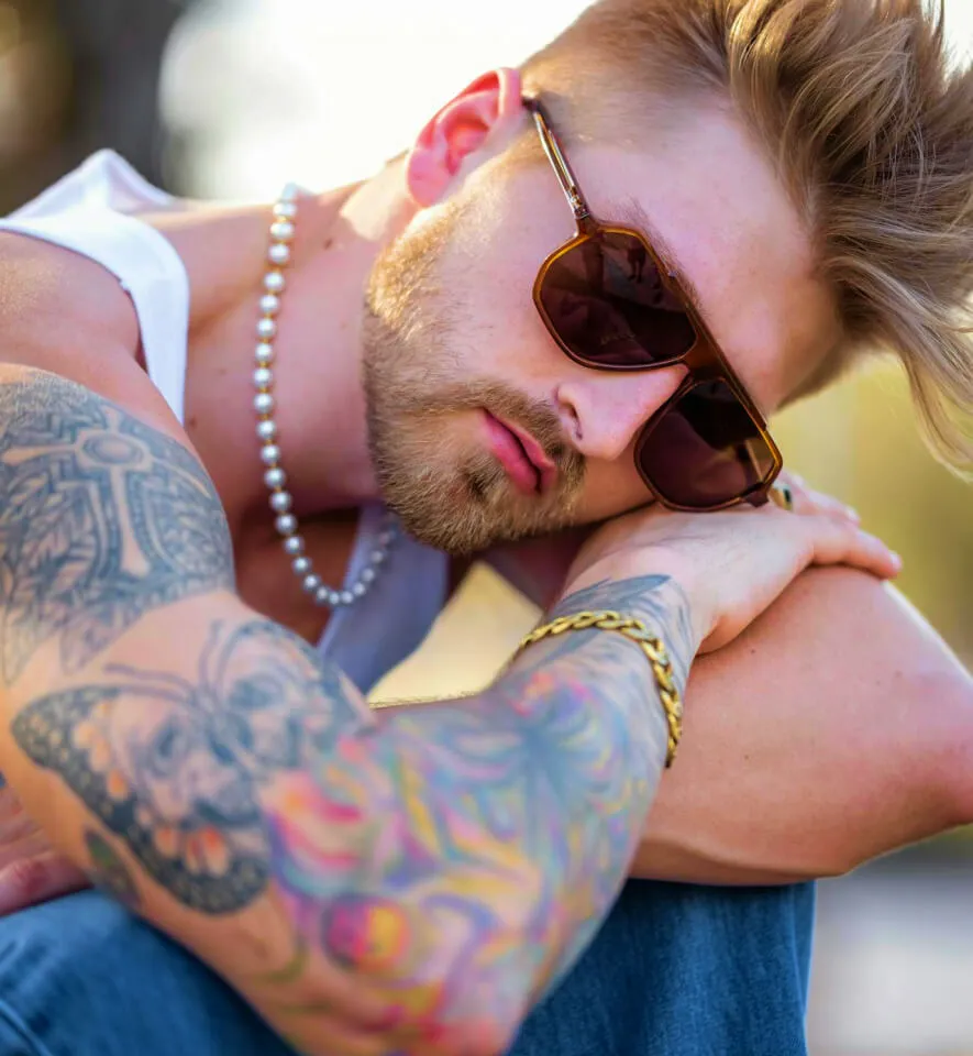 man in shades rests head on his arms