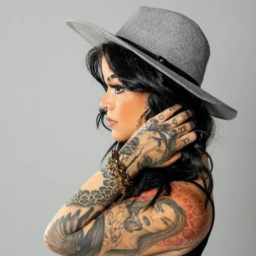 a woman wearing gray hat with arms full of tattoo