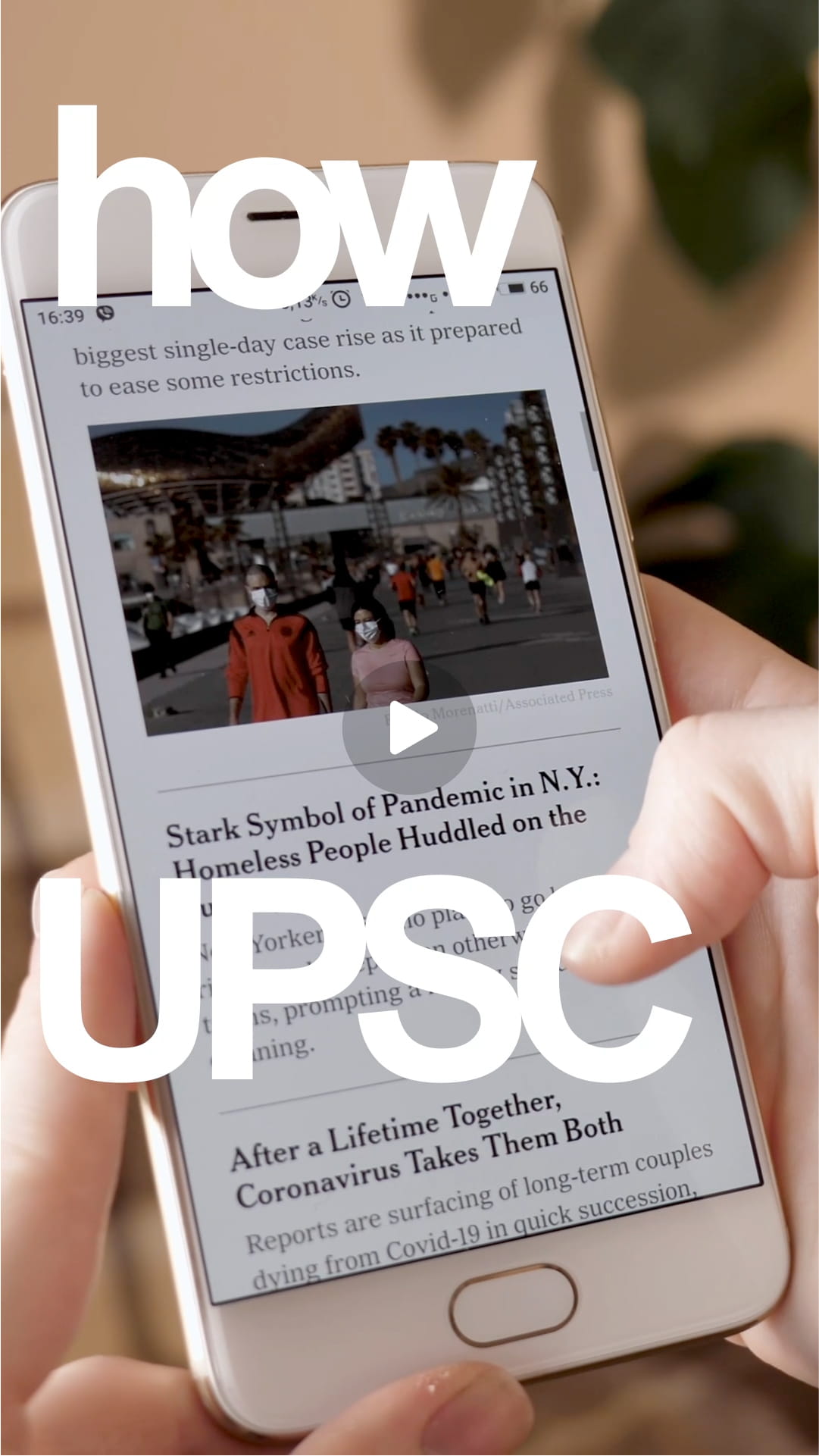 A person holding a smartphone displaying news headlines about the pandemic, including an image of people wearing masks outdoors.
