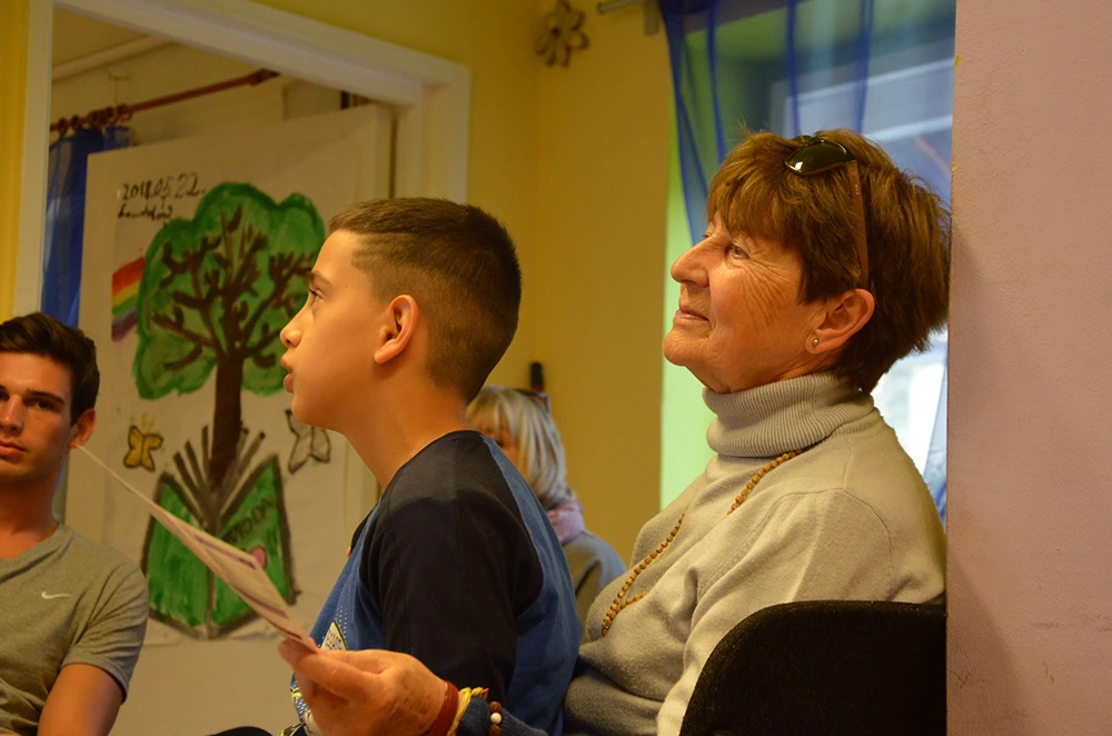 Tanodás gyermekek és egy önkéntes közös foglalkozáson vesznek részt.