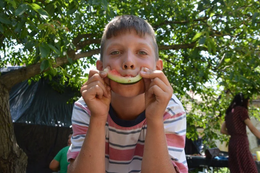 Tanodás gyermek, amint éppen egy szelet dinnyét eszik jóízűen.