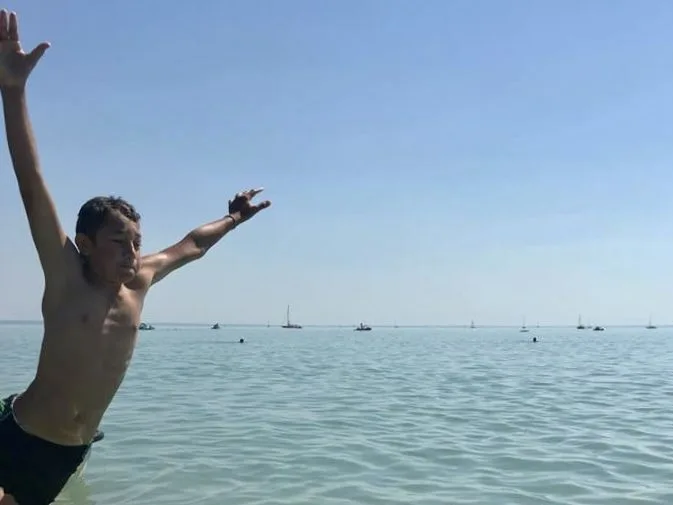 Vidám Tanodás gyermek, ahogy beleugrik a Balatonba.