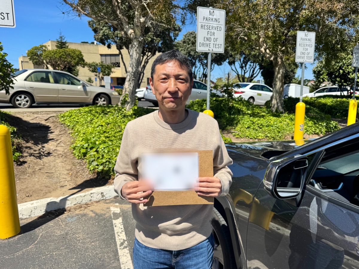 LLG Driving School student holding DMV test results outside a DMV office
