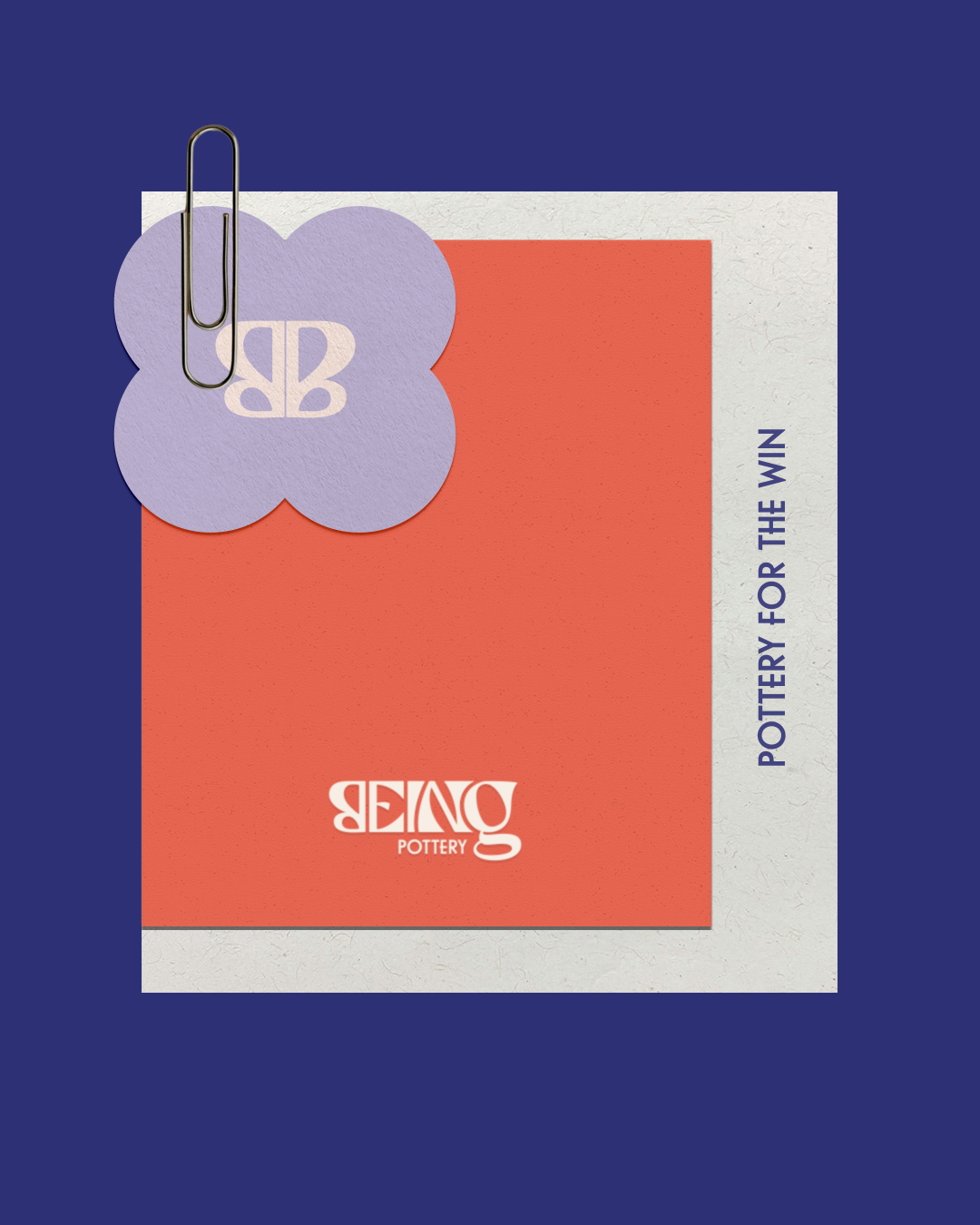 Stationery set with a purple flower-shaped paper clipped note displaying stylized BB logo, a red square paper with 'BEING POTTERY' logo, and a cream border with text 'POTTERY FOR THE WIN' on a dark blue background.