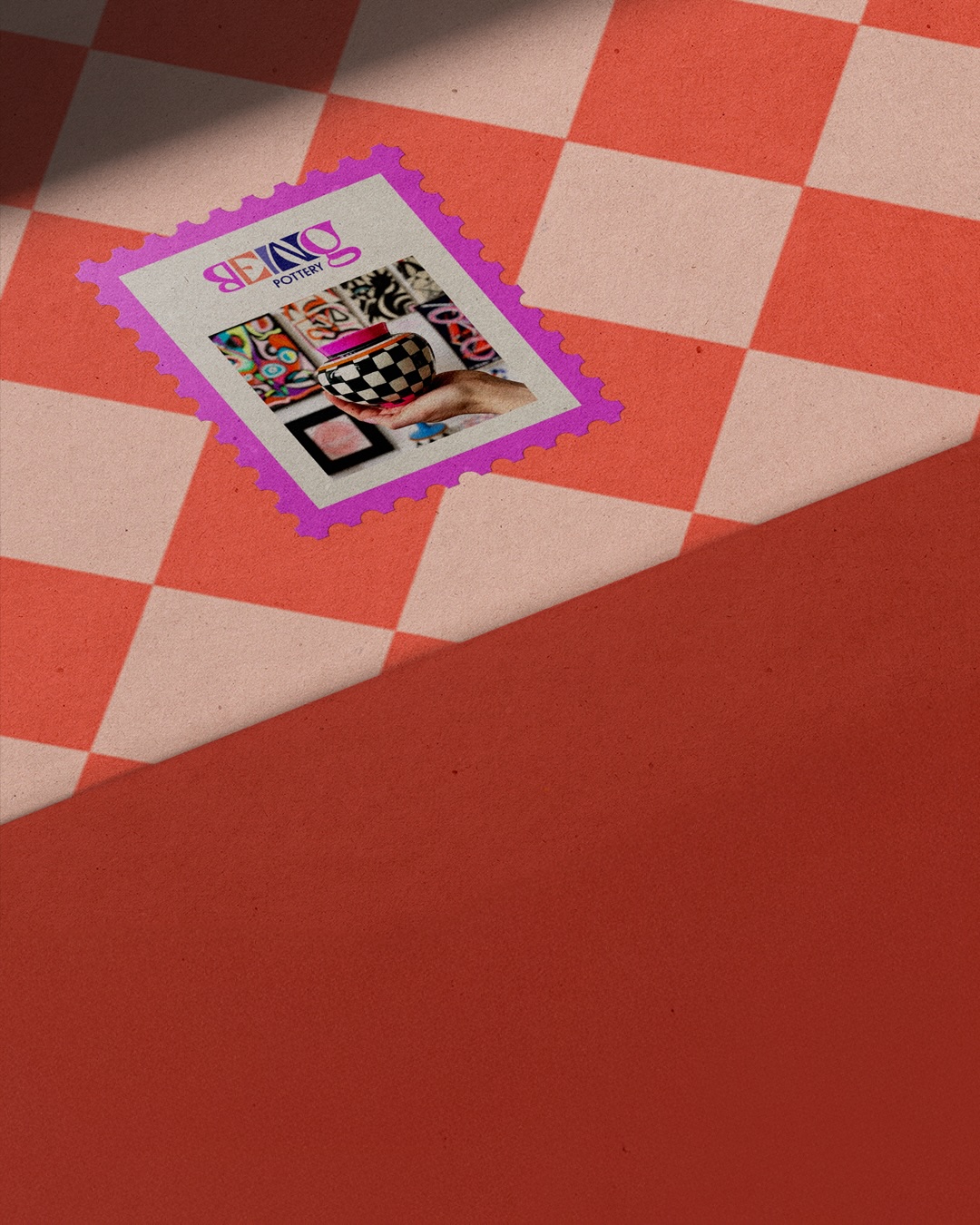 Colorful branded postage stamp featuring a hand holding a black and white checkered pottery vase with a pink lid, set against a background of vibrant artistic patterns. 