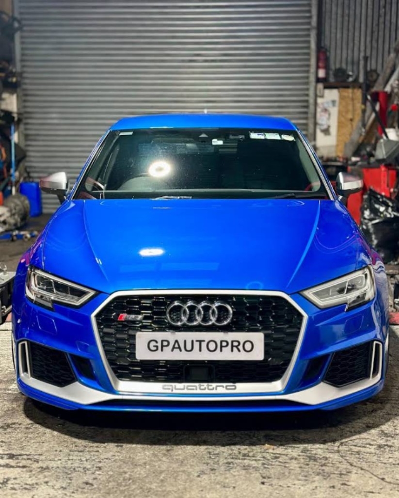 Front view of a blue Audi S3 Quattro car with a GPAUTOPRO license plate inside a garage.