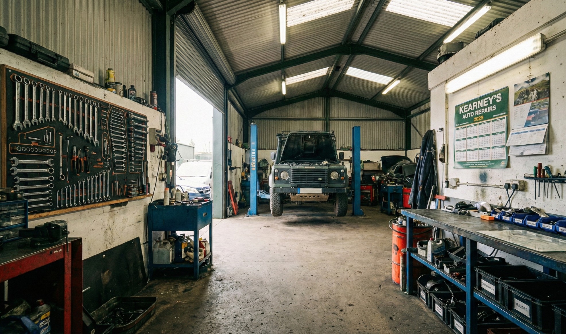 Clean and organized auto repair workshop with a vehicle on a hydraulic lift and tools neatly arranged on walls and shelves.