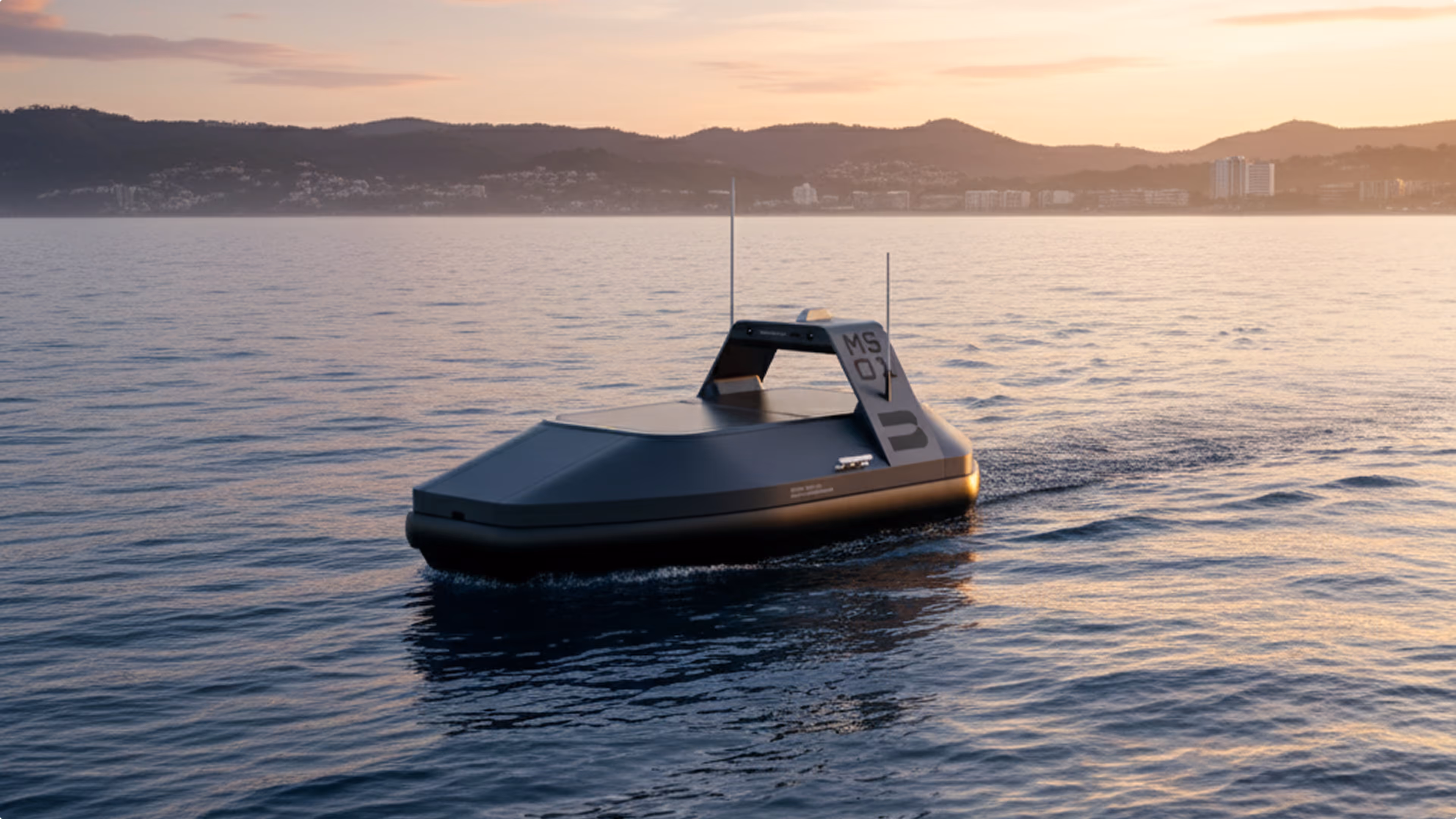 Autonomous black vessel gliding on calm sea at sunset with distant hills in the background.