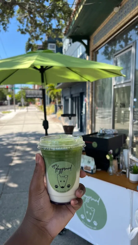 A Sage's Playground matcha held in front of the coffee cart