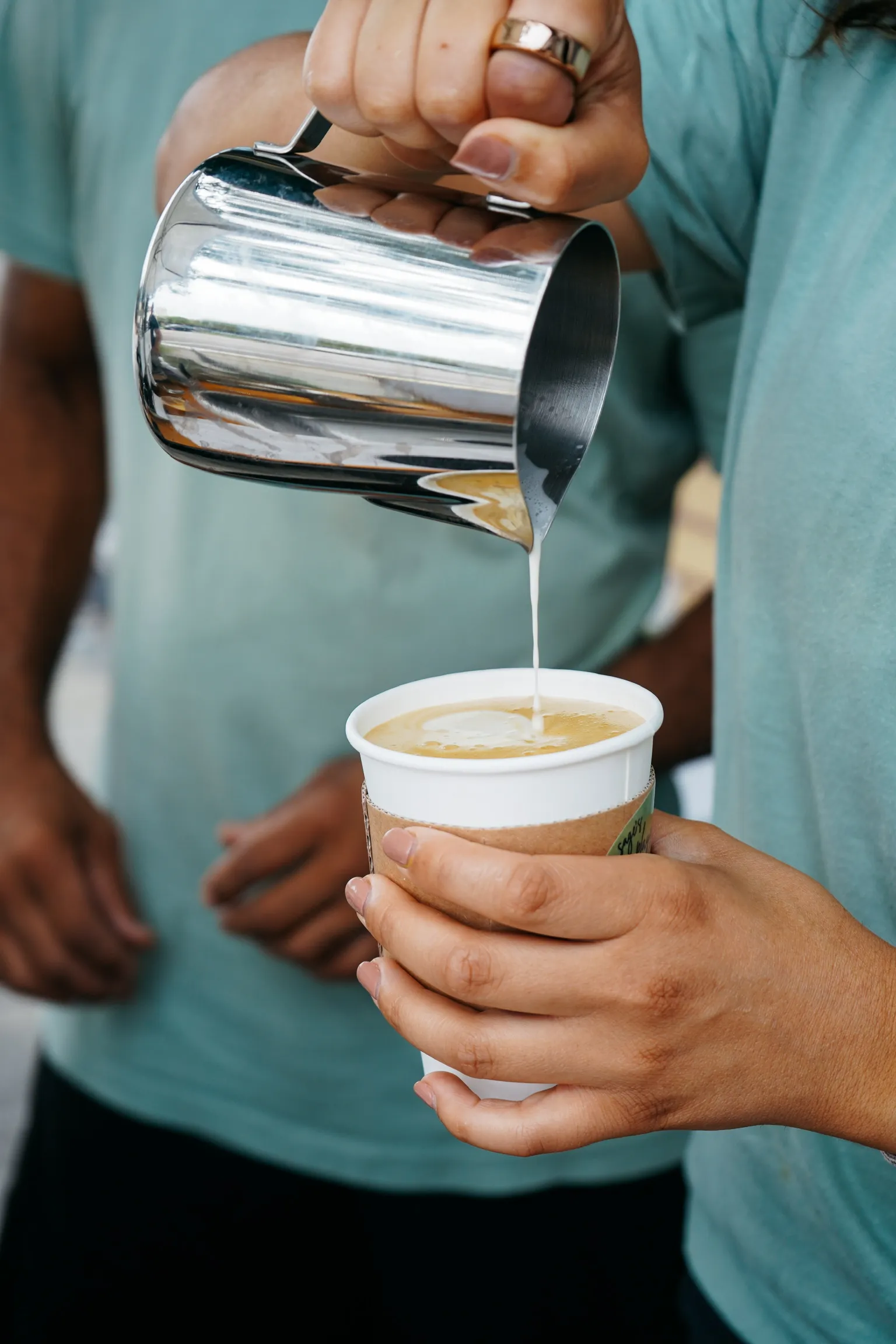 Hand holding a Sage's Playground coffee cup at a Tampa Bay event