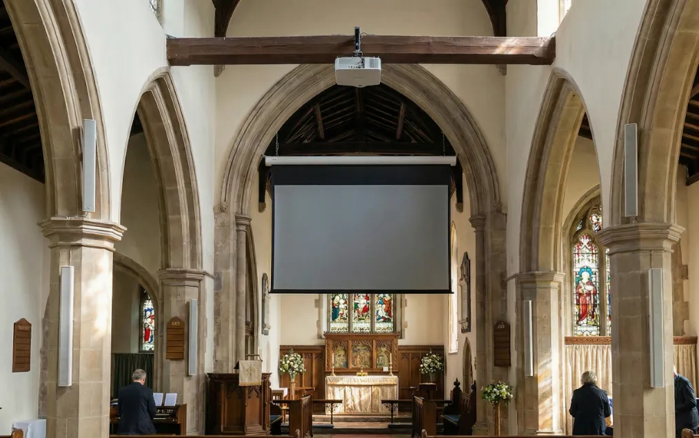 Kirche mit Beamer und Projektionsleinwand über dem Altar – Promedia integriert Medientechnik und Beschallungsanlagen in denkmalgeschützte Sakralbauten im DACH-Raum.