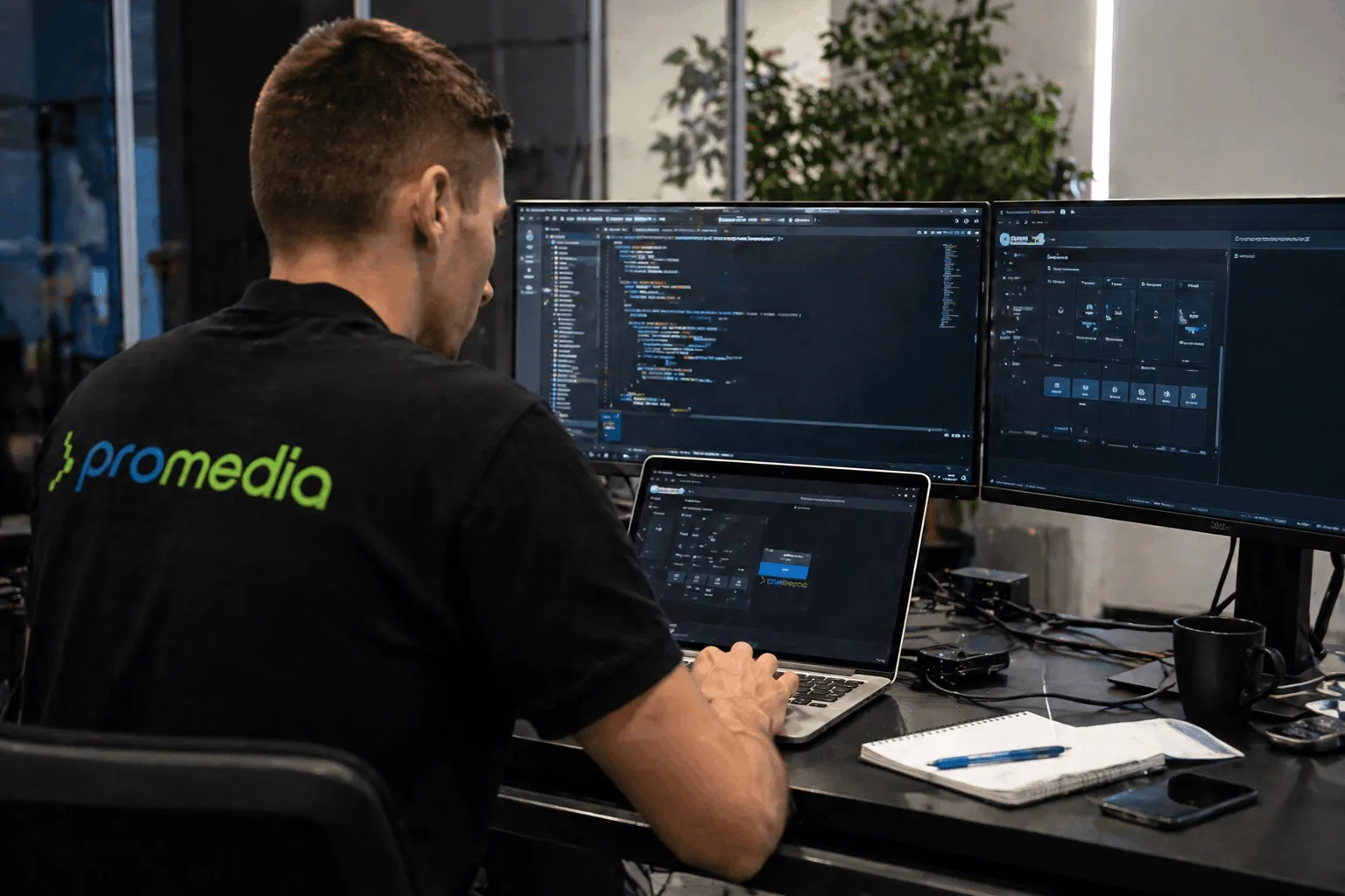 Promedia-Techniker bei der Programmierung von Crestron- und AV-Steuerungssystemen für Konferenzräume an einem Dual-Monitor-Arbeitsplatz in Hockenheim.