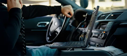 Photo of a law enforcement supervisor speaking on his car radio.
