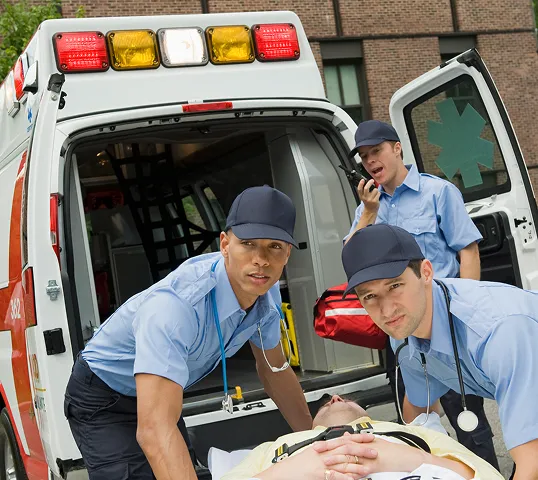 EMS professionals wheeling a patient on a gurney.