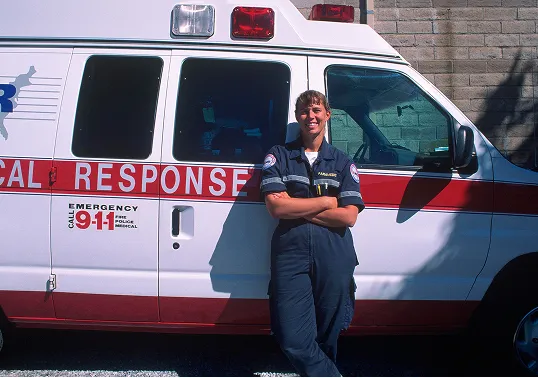 An EMT standing in front of an ambulance. 