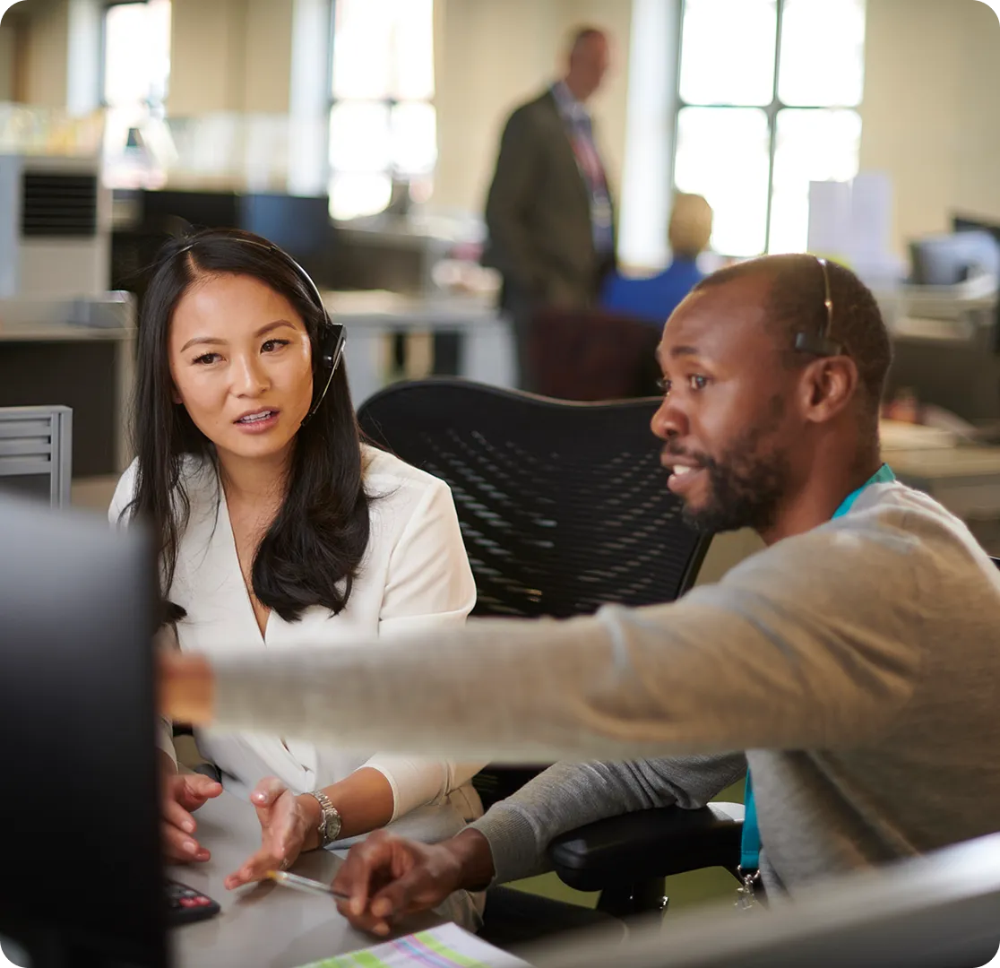 A 9-1-1 supervisor demonstrating simulation software to a dispatcher.