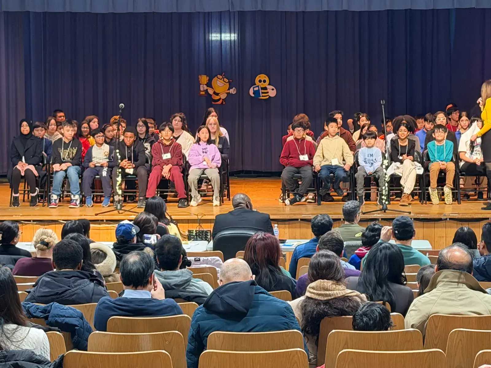 Students seated on stage during a school spelling bee competition