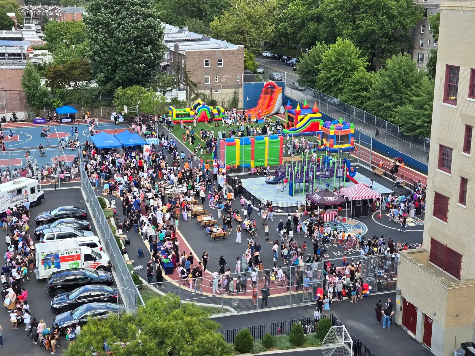 Students and families enjoying outdoor carnival with inflatables at school event