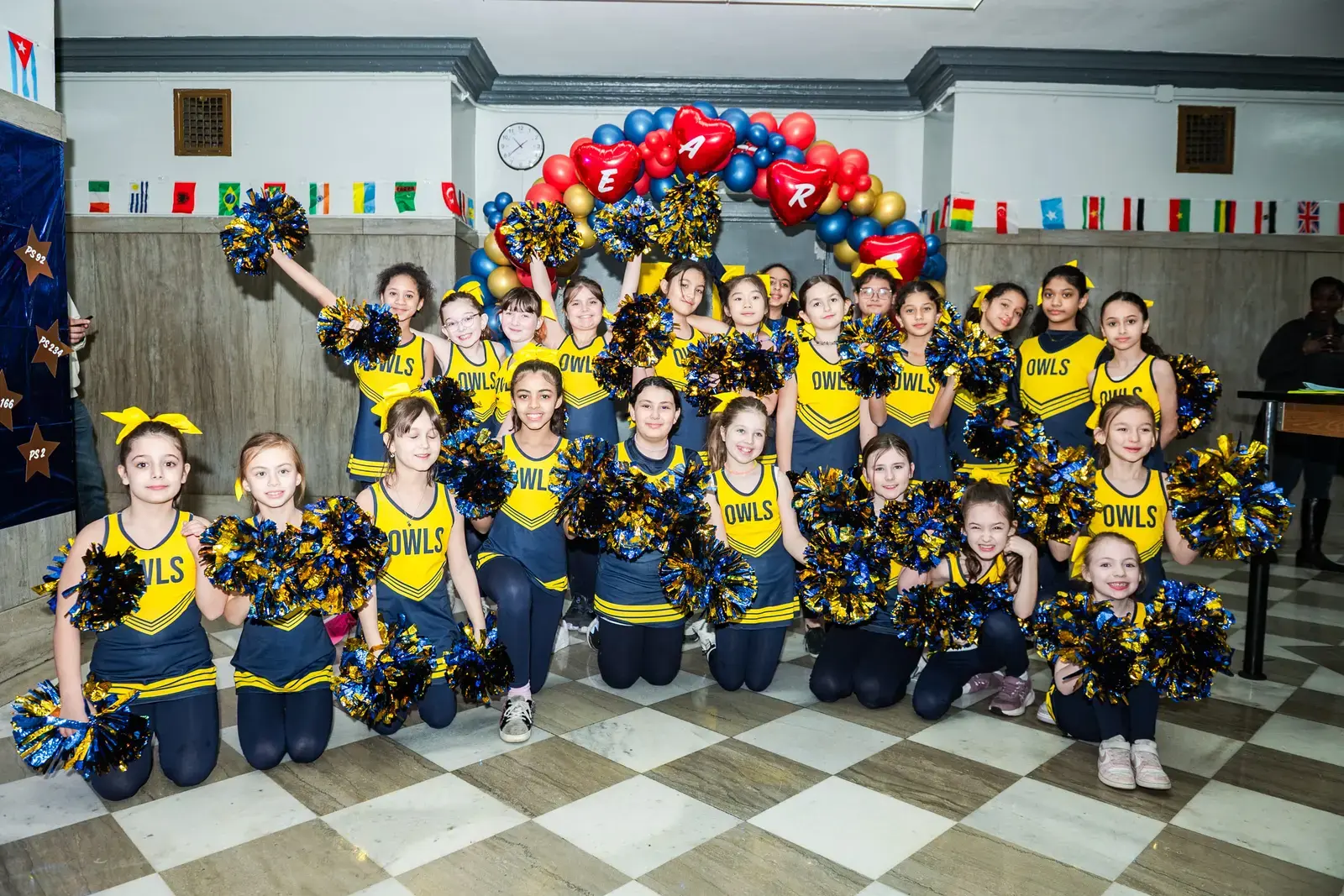 Owls cheerleading squad posing with pom-poms at school event