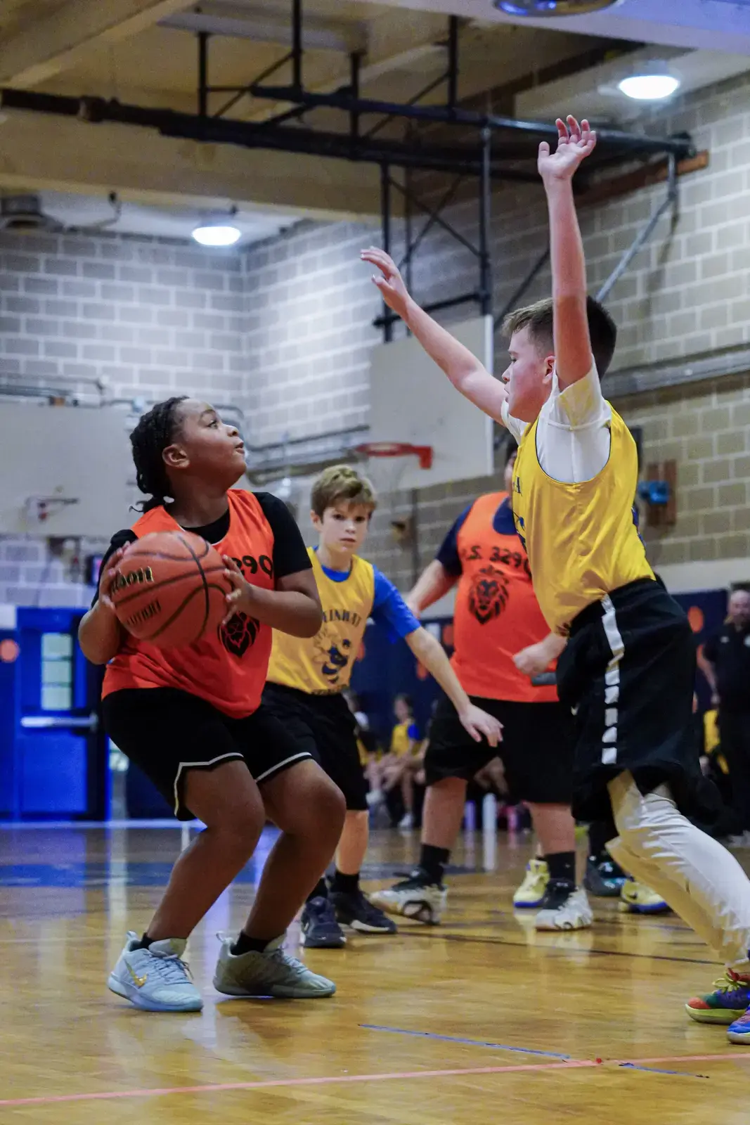Students competing in a school basketball game inside a gymnasium