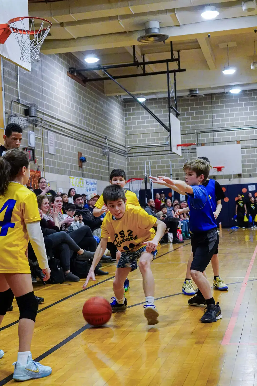 Students playing basketball during a PS 2 Queens school gym game