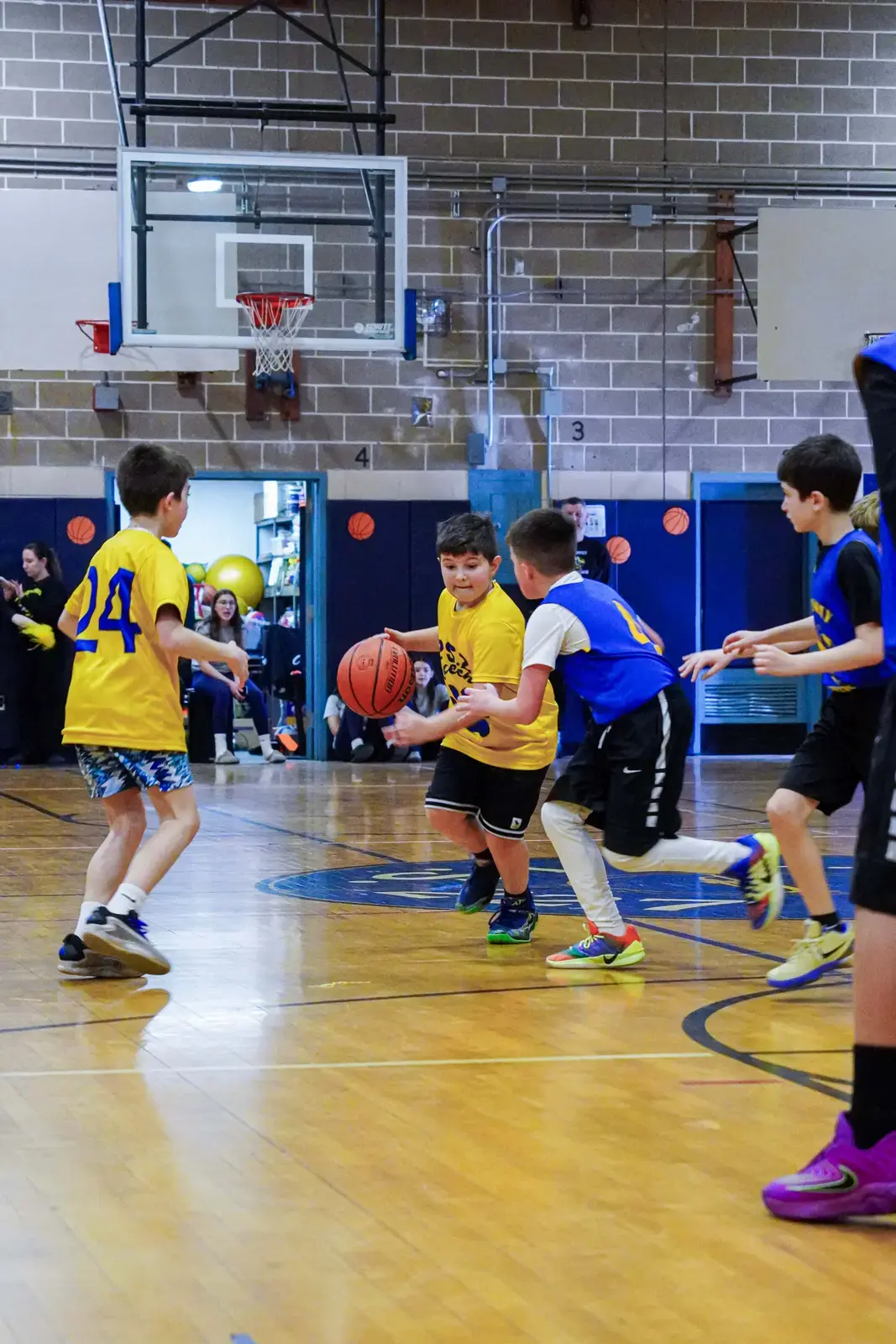 Students playing basketball during an indoor school gym game