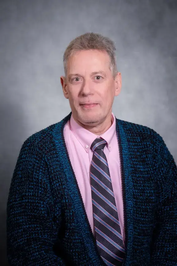 Staff portrait of a male faculty member in a cardigan and tie