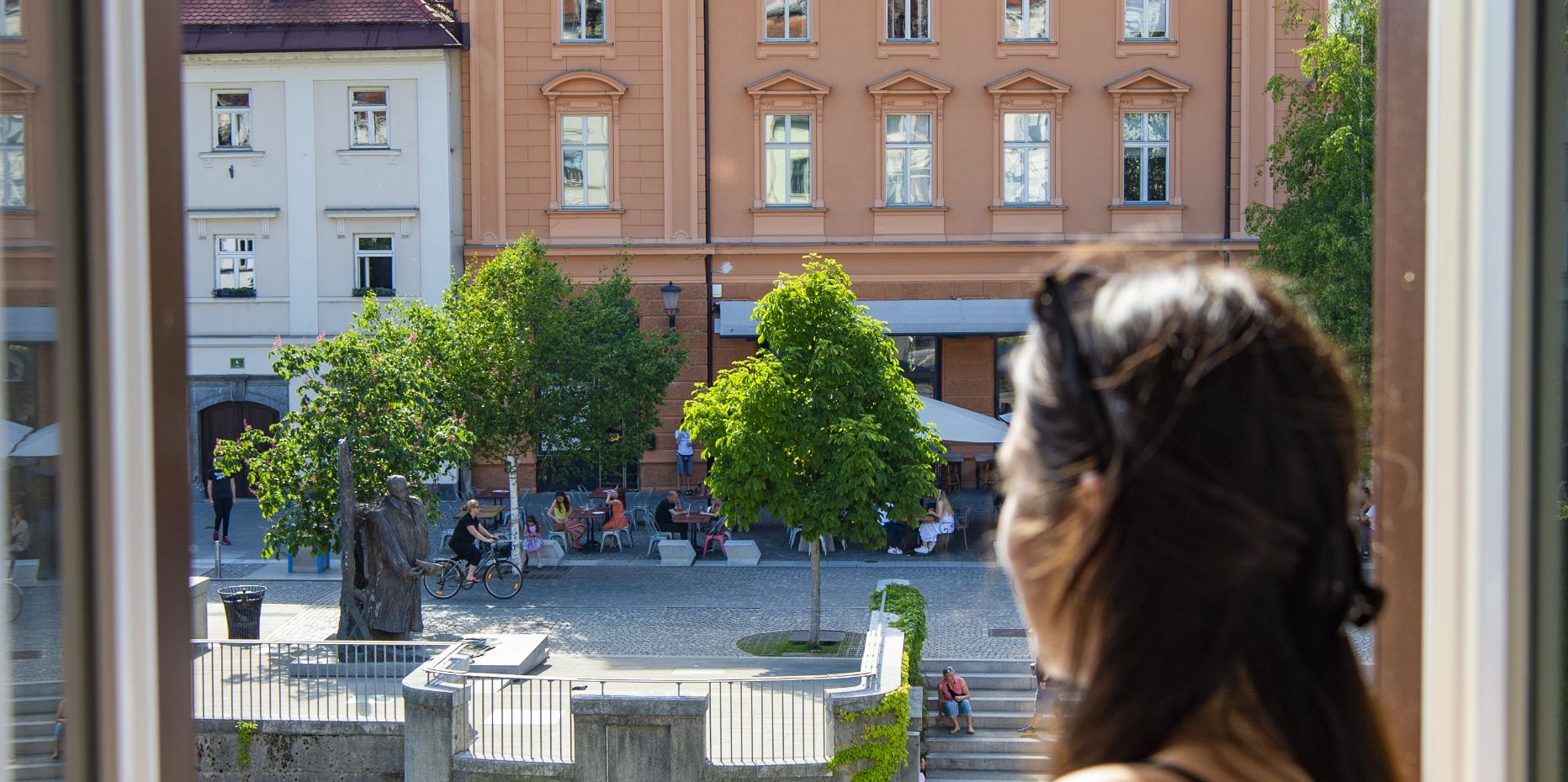 Beautiful woman looking outside of her window in Ljubljana.
