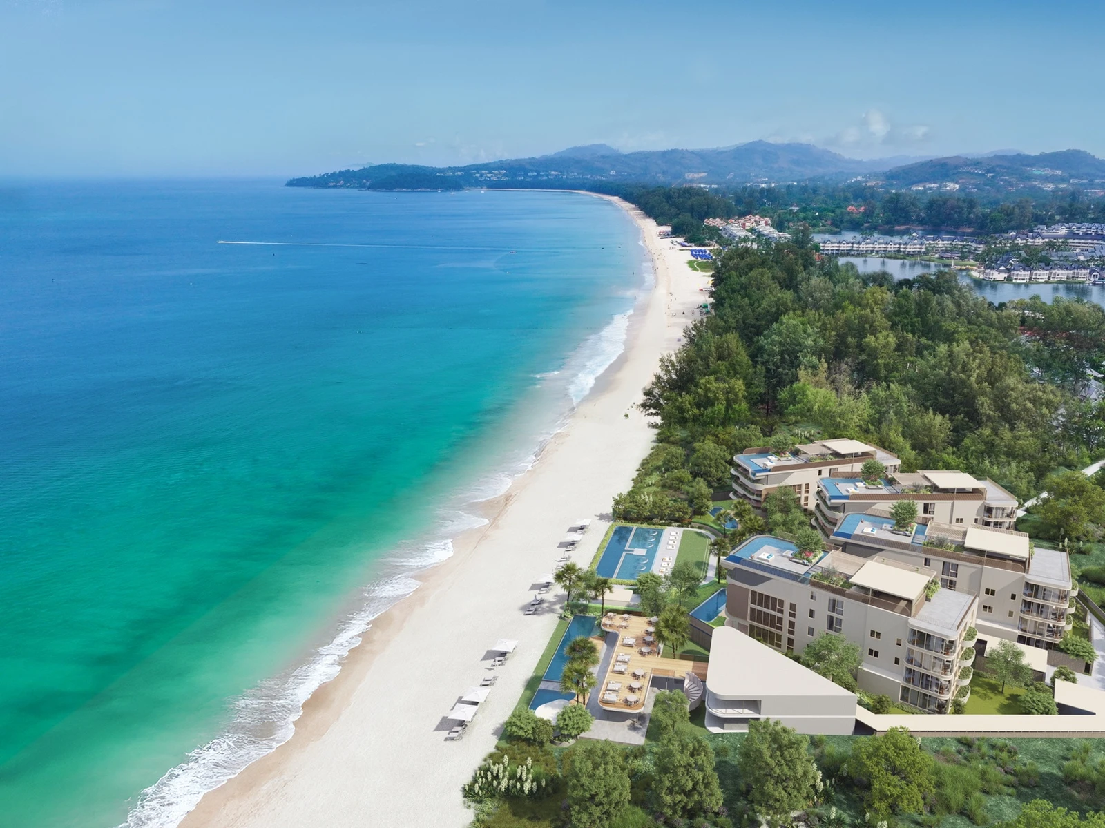 Aerial view of beachfront residences along a long curved coastline