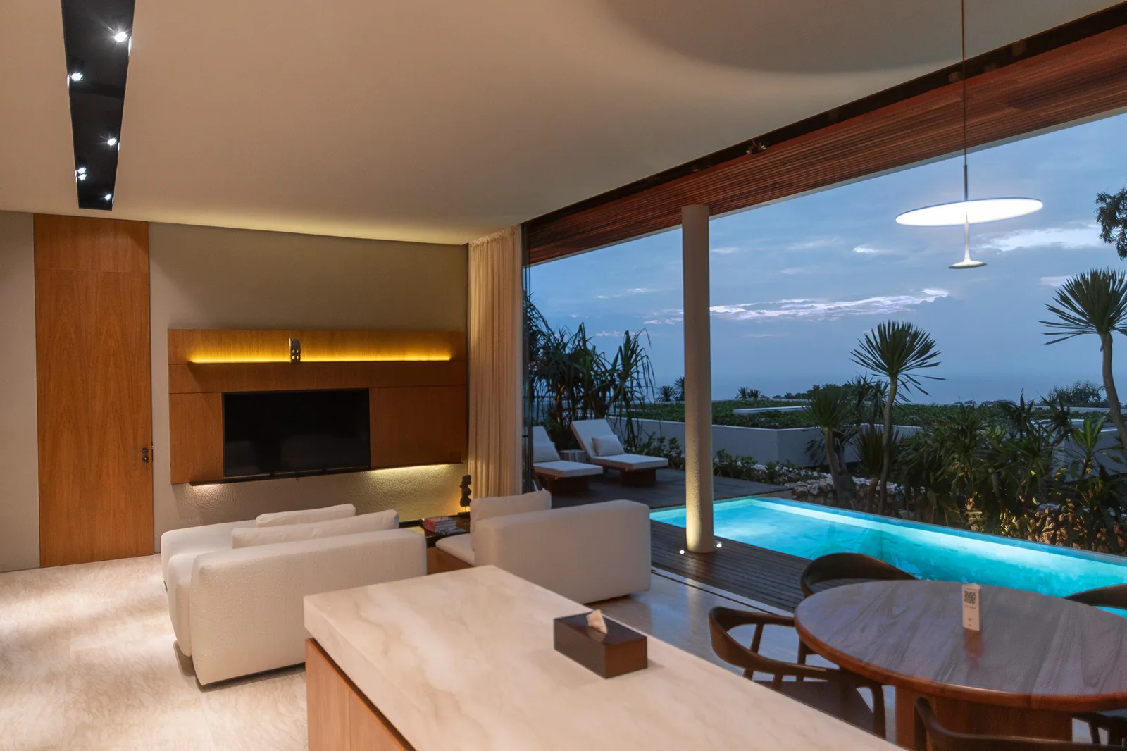 Open living area with private pool and ocean outlook at dusk