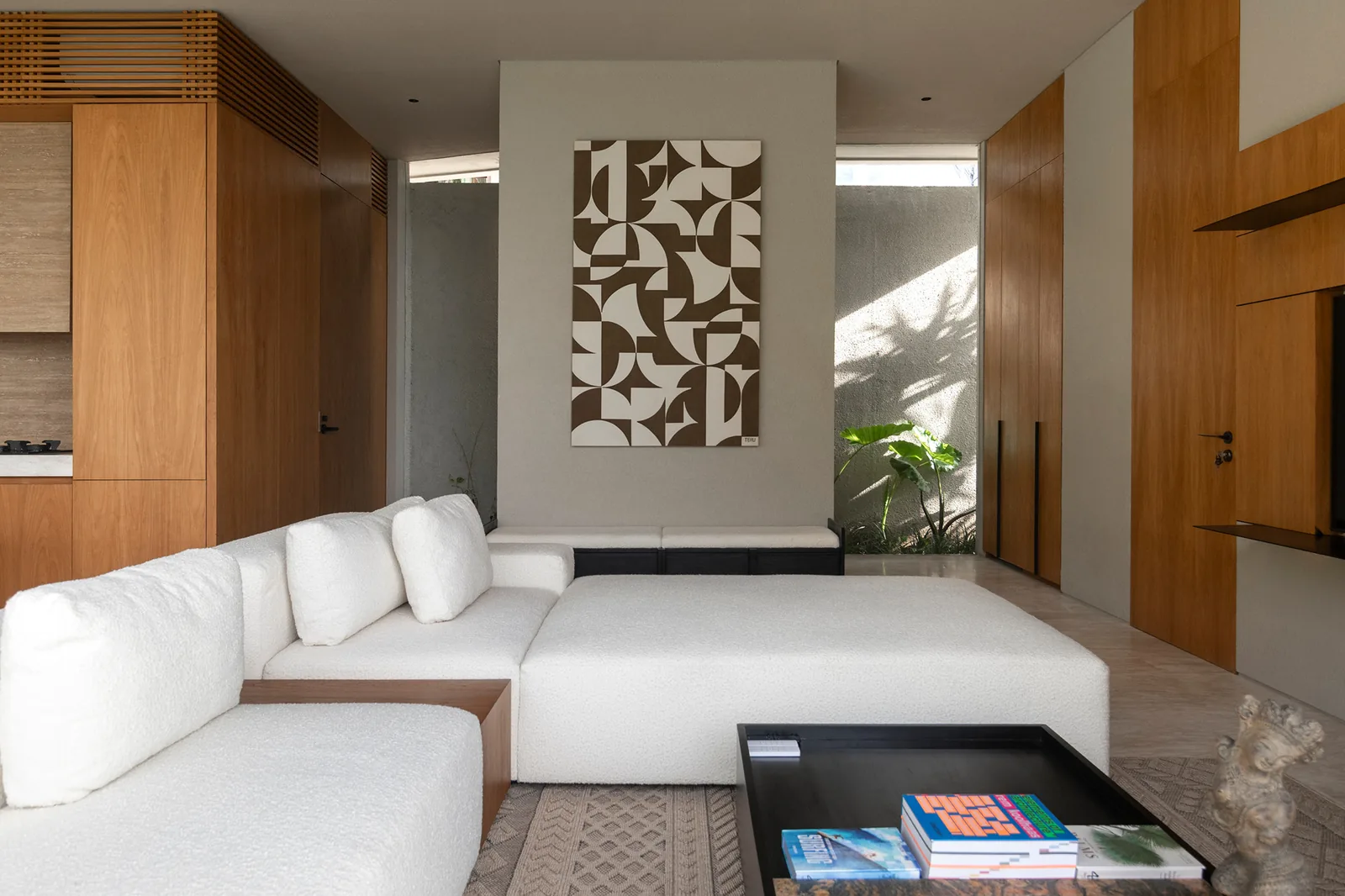White sectional sofa and geometric art wall in living area