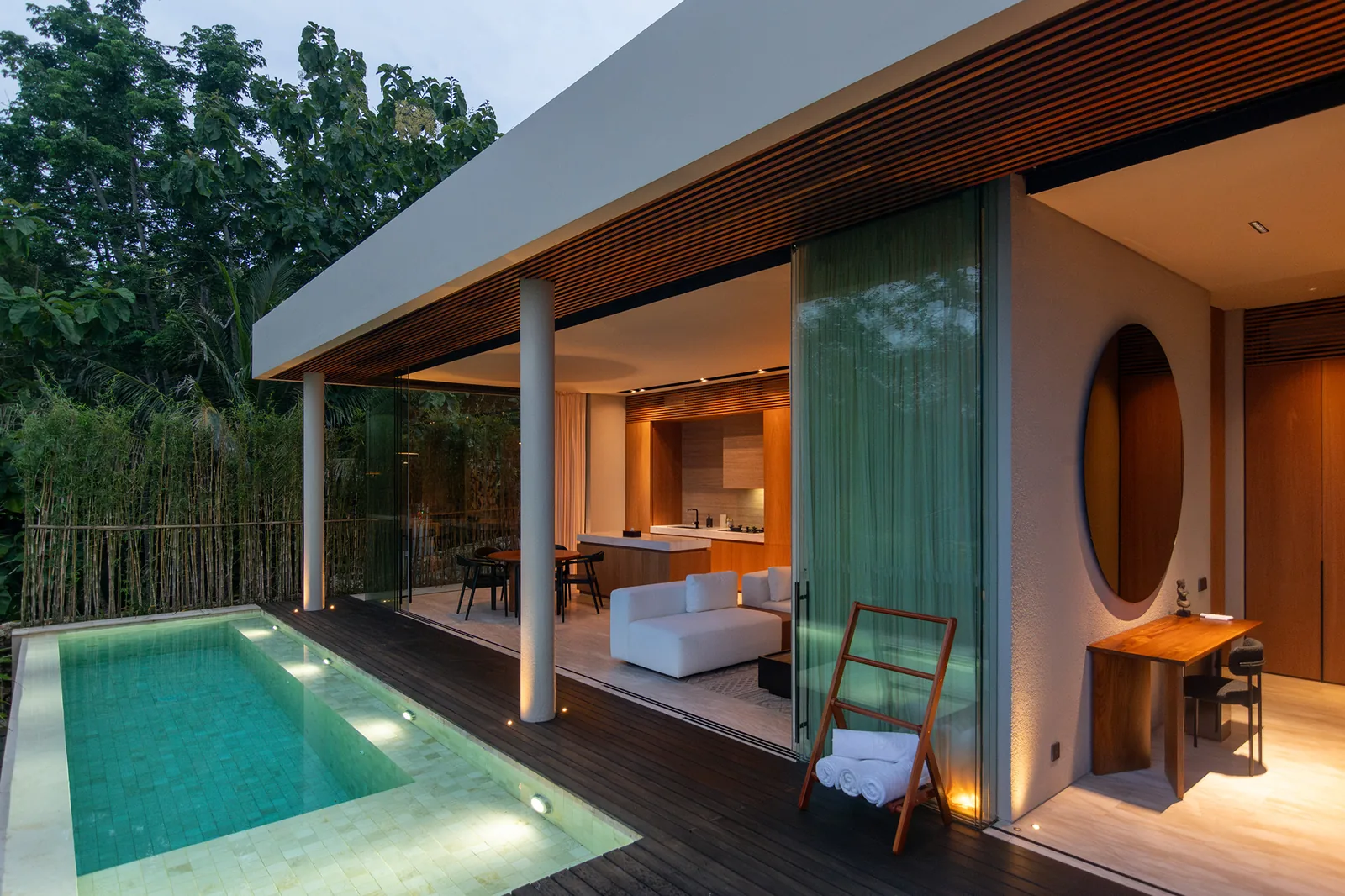 Pool deck and villa exterior with bamboo screen at dusk