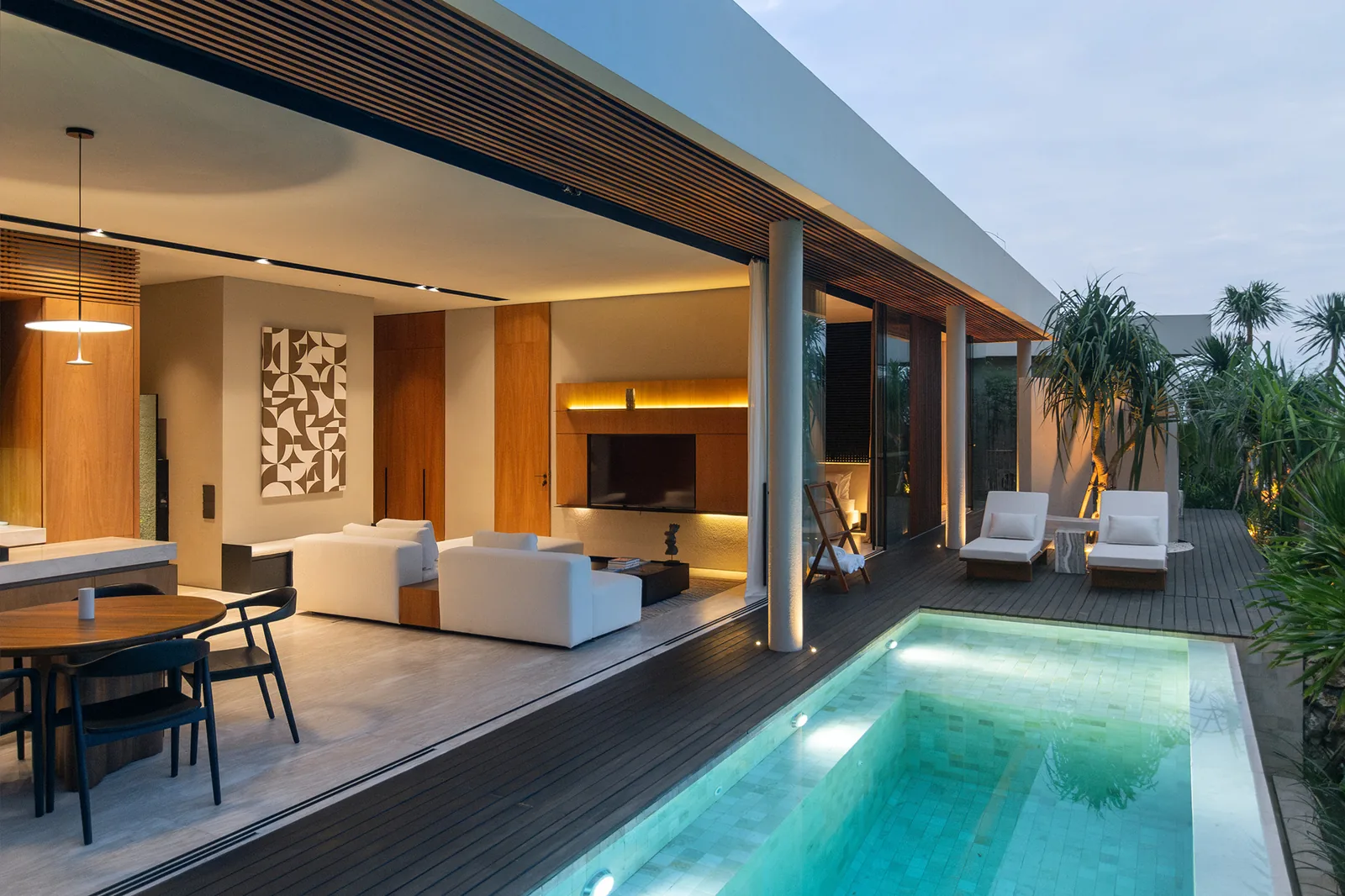 Private pool terrace with open living pavilion at twilight