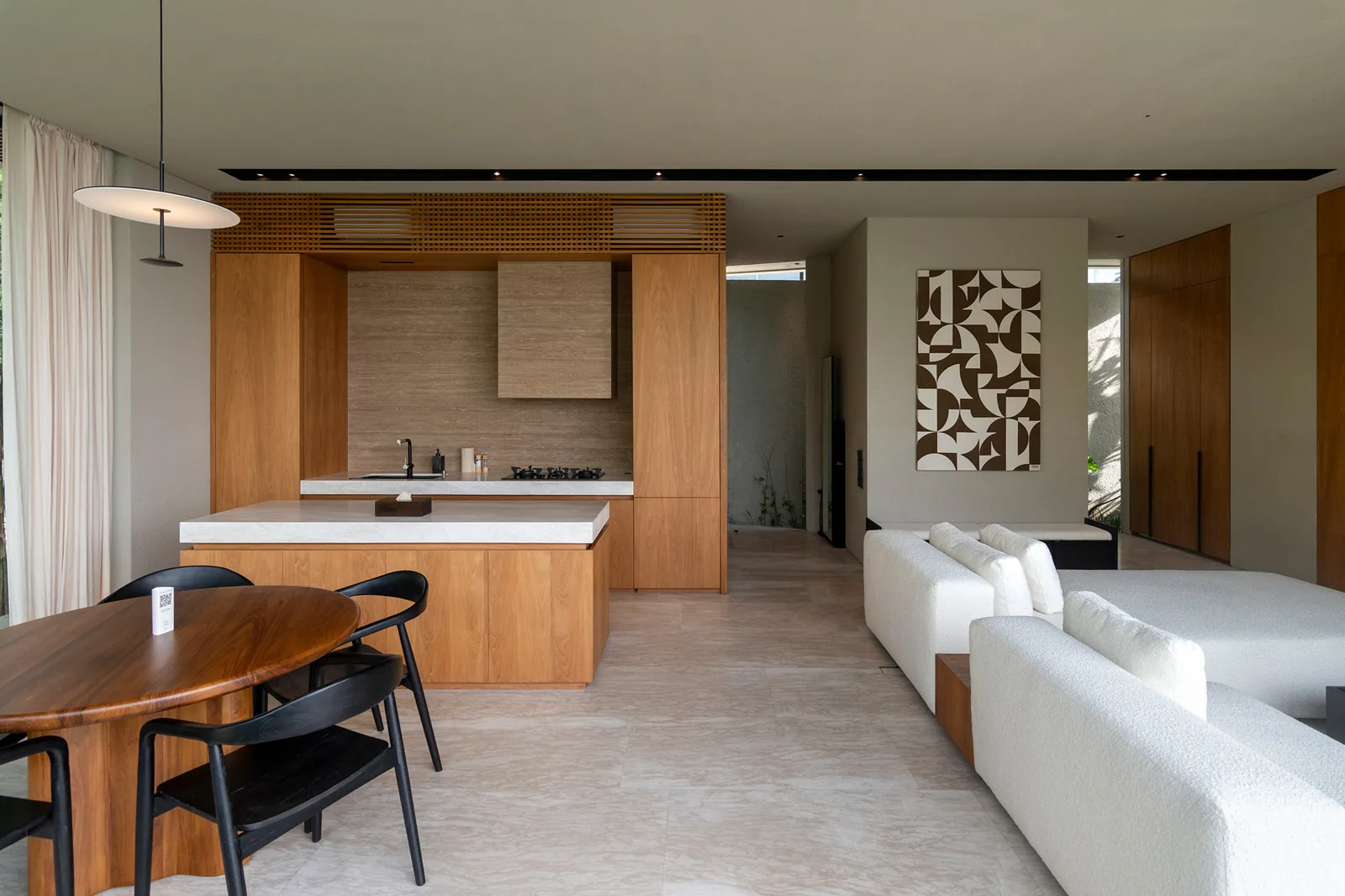 Open-plan kitchen, dining, and living area with art wall