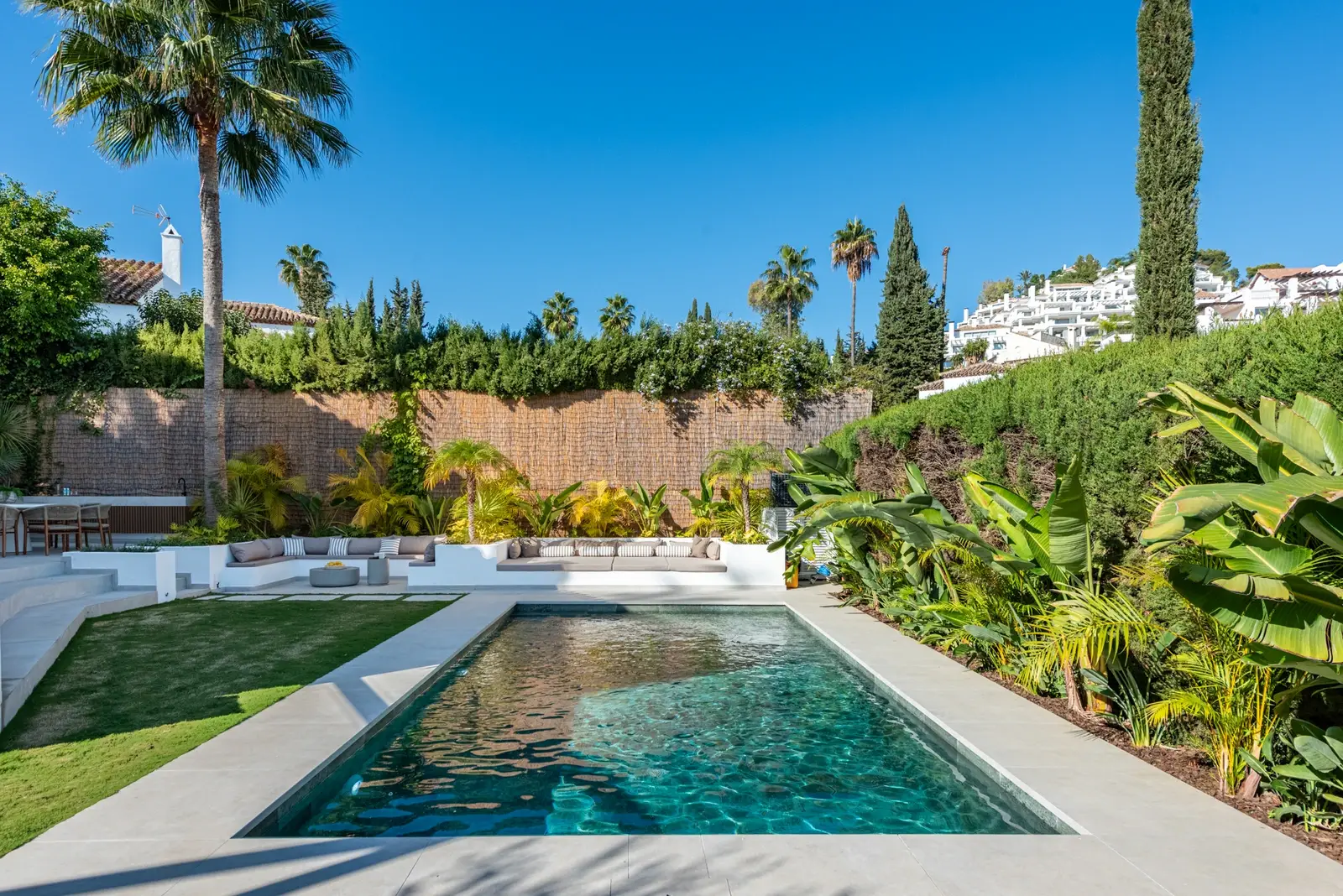 Pool and garden with built-in seating and tropical planting