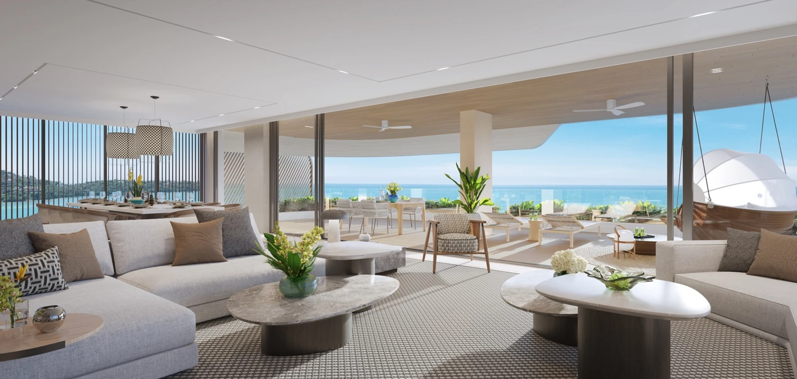 Living room opening to a large terrace with ocean view