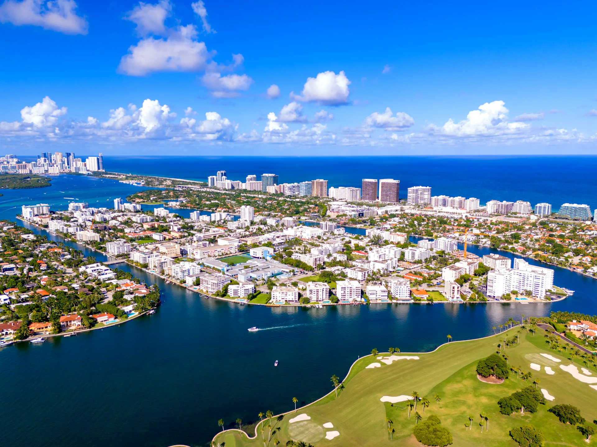 Aerial view of Bay Harbor Islands, Miami - low-rise waterfront condos on canal-laced islands in Biscayne Bay, with Bal Harbour and the Atlantic Ocean behind