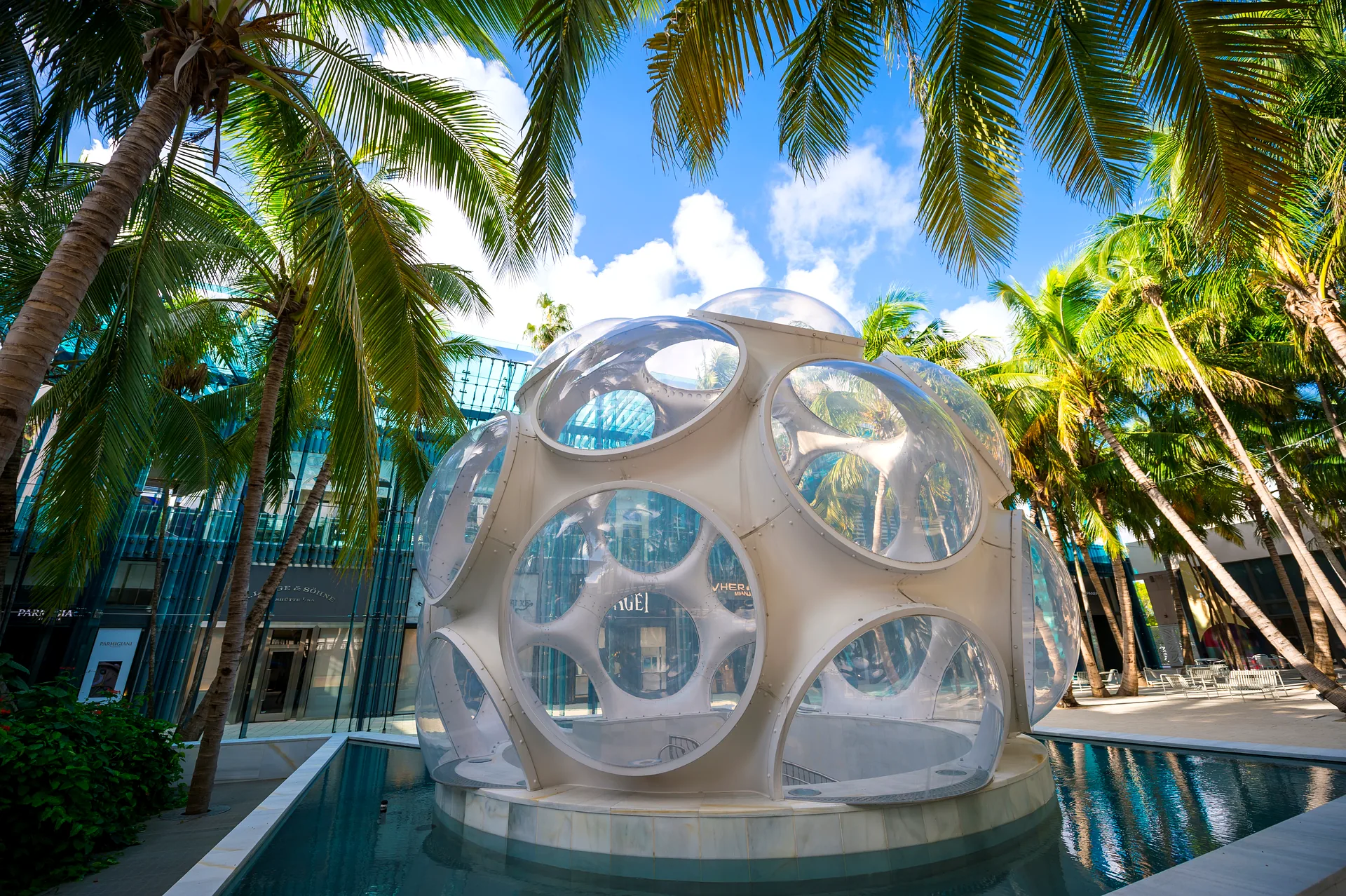 Fly's Eye Dome sculpture in Palm Court, Miami Design District - geodesic landmark surrounded by palm trees and luxury retail storefronts