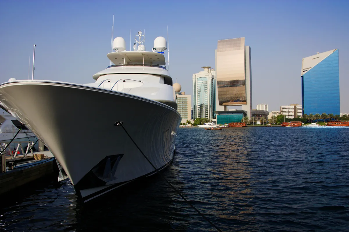 A superyacht moored before Dubai Creek towers, illustrating the UAE's tax-free residency base