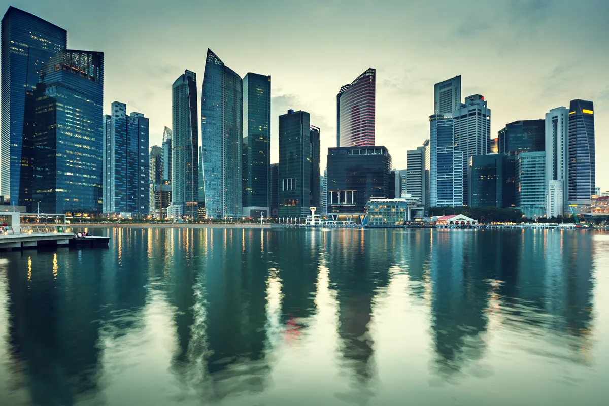 Dusk view of Singapore's central business district skyline across Marina Bay.